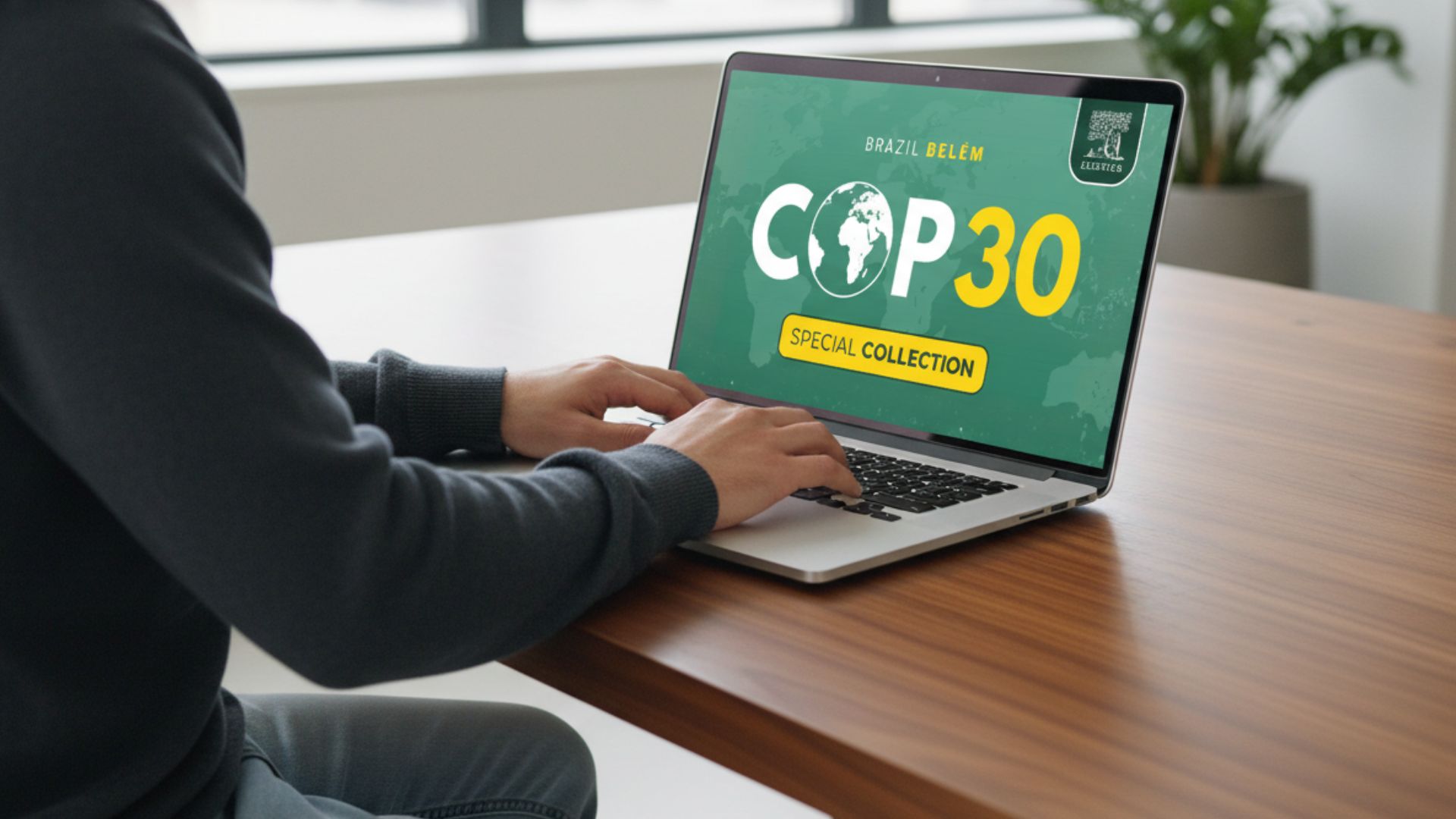 A man working on a laptop that is placed on a brown wooden desk. On the screen is the COP 30 special issue title.