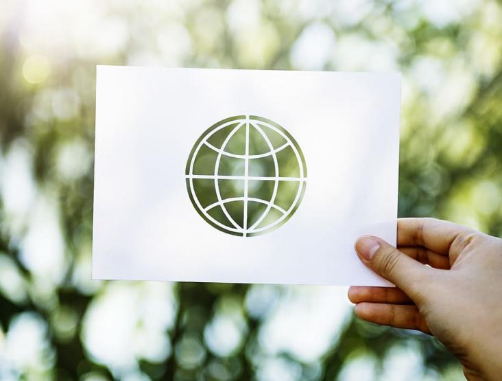 Hand holding paper globe cutout
