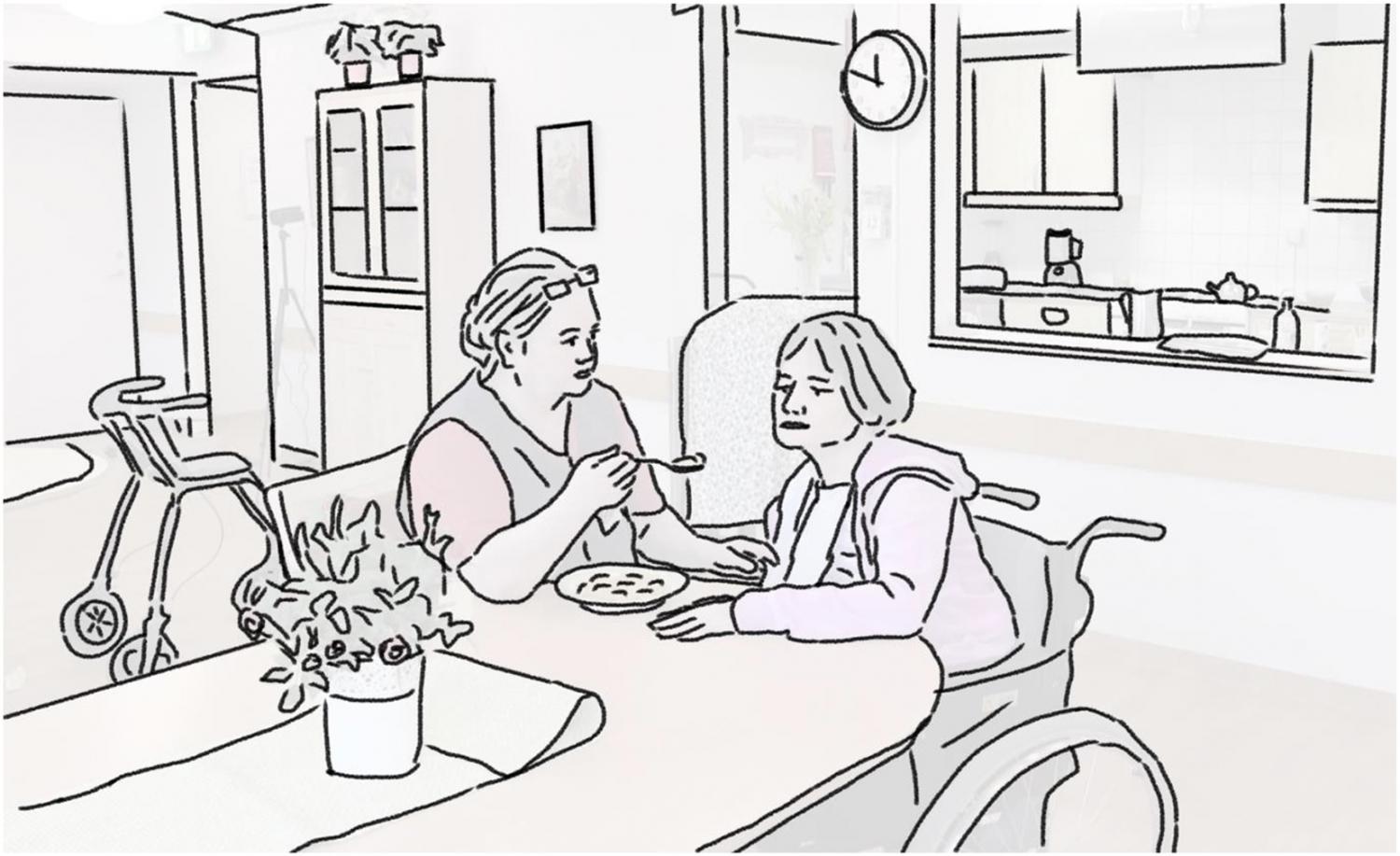A carer (on the left) gives food to the person with dementia (on the right). A carer (on the left) gives food to the person with dementia (on the right).